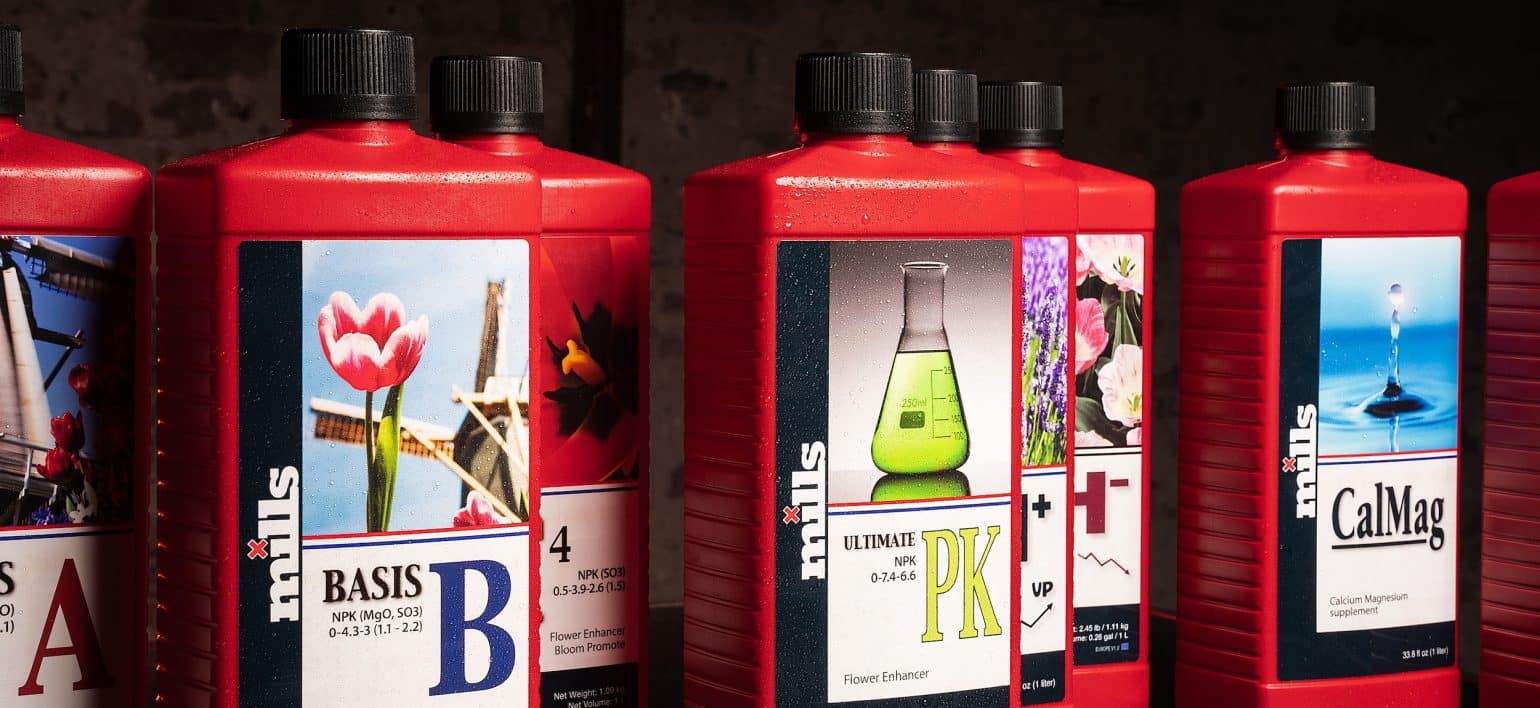 Close up and side on view of full Lineup of Mills Nutrients 1L bottles including Start-R, Basis A&B, C4, Ultimate PK, Vitalize, CalMag and pH control