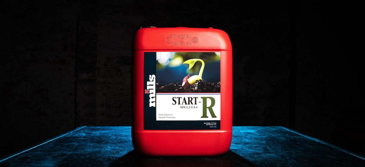 Red container of Mills Start-R placed on blue-lit tabletop, spotlighting young cannabis seedling graphic on label